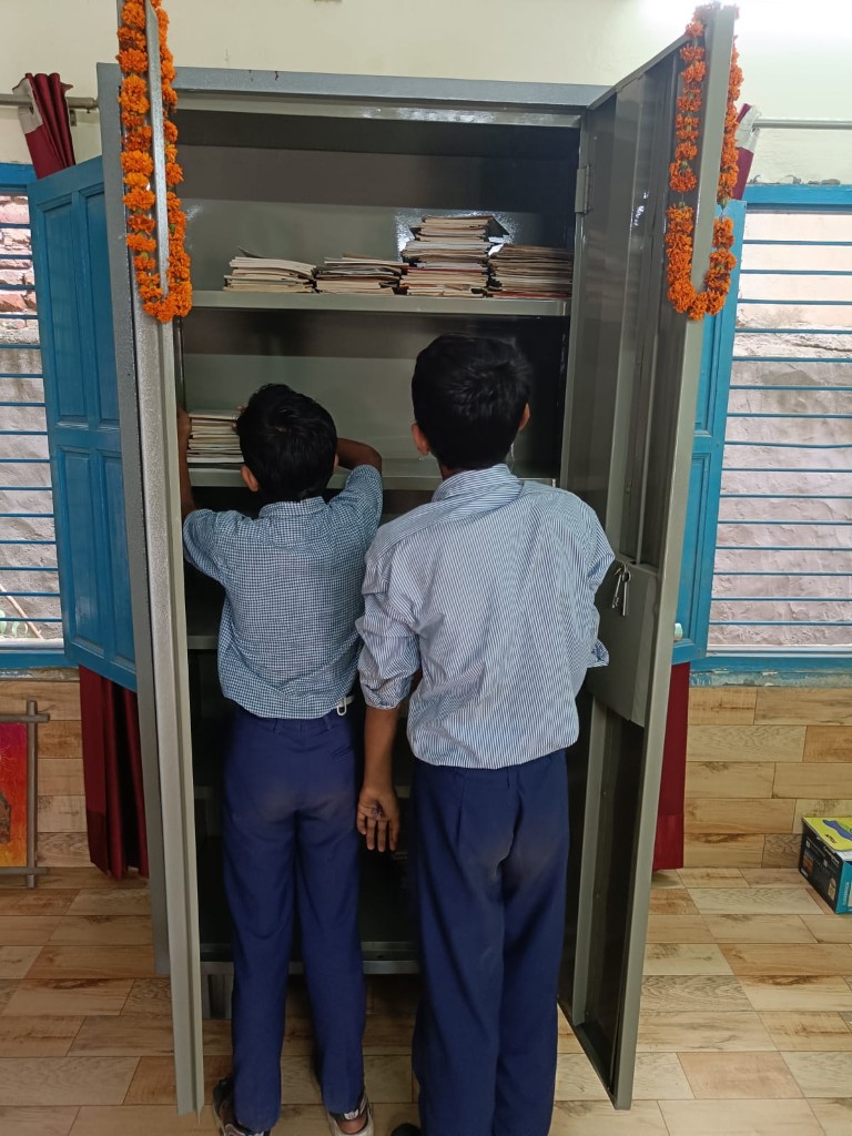 Students stocking a new science lab cabinet at a partner government school